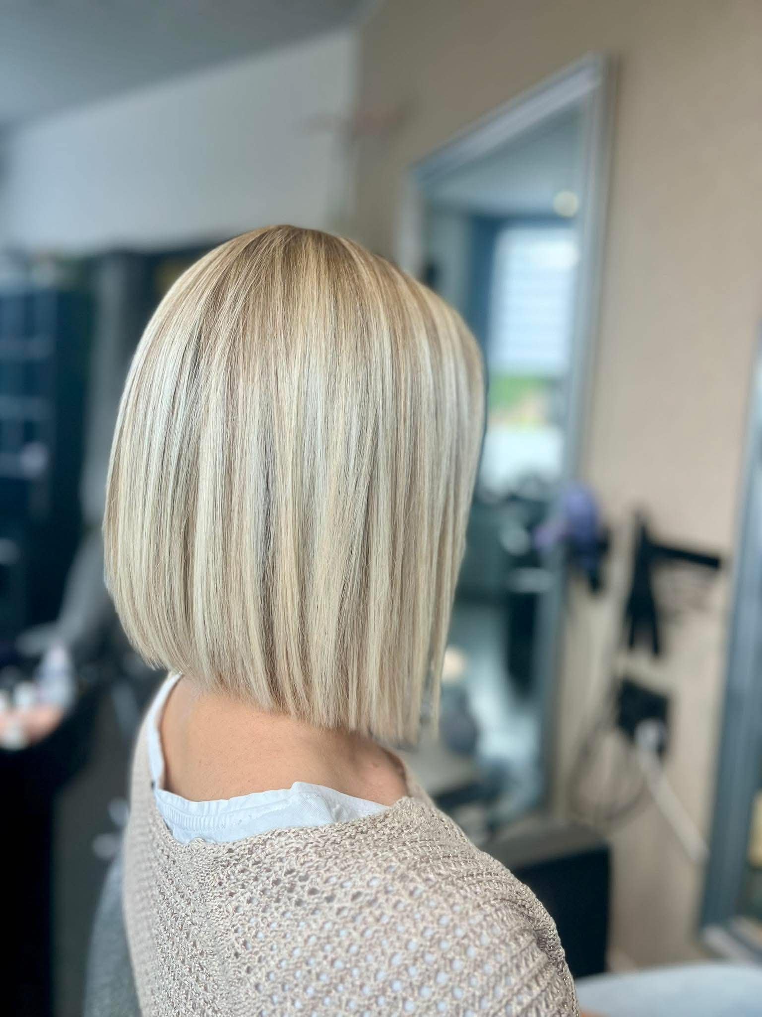 Carré blond lumineux aux mèches claires réalisé au salon