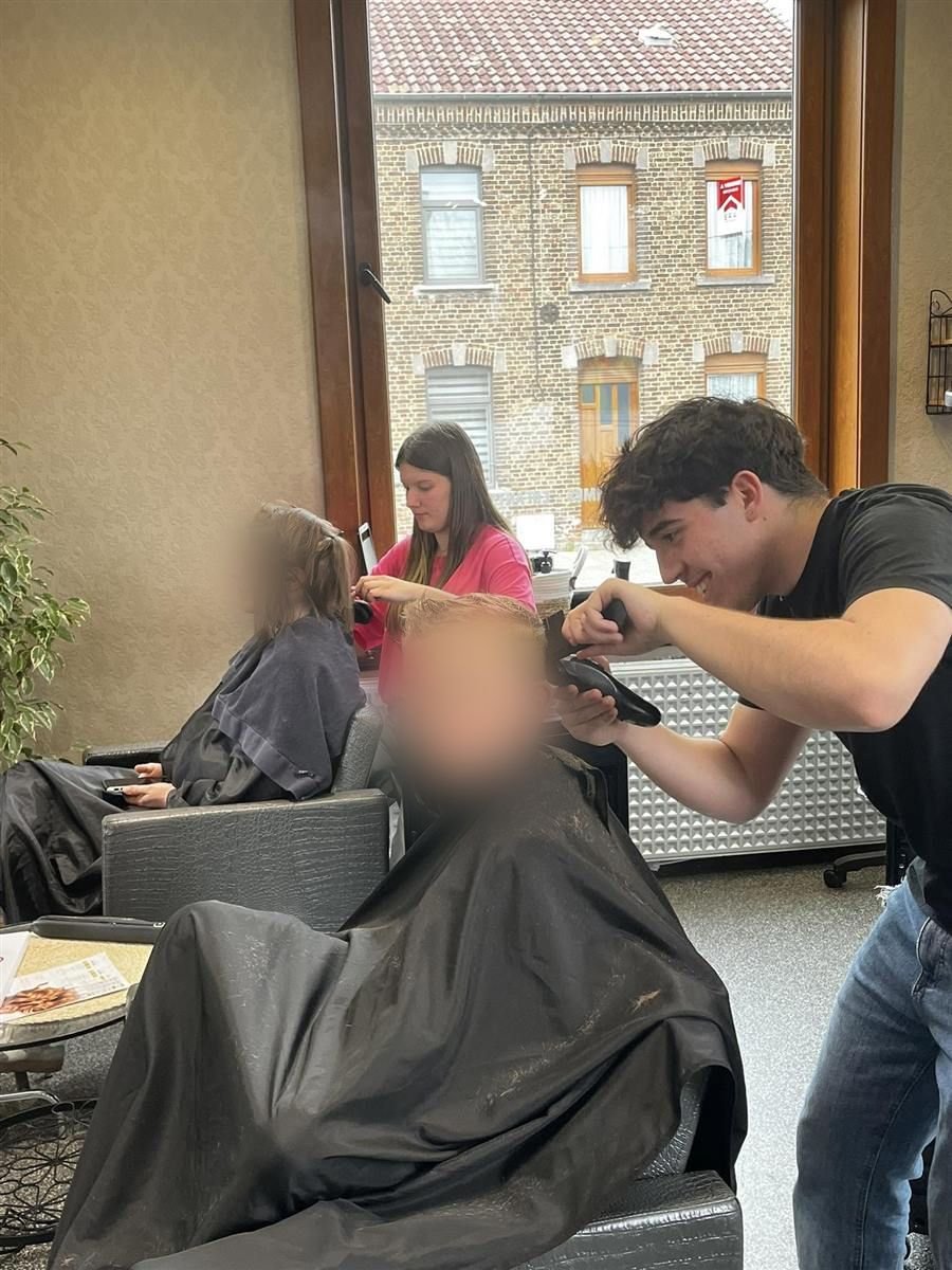 Un enfant souriant pendant sa coupe au salon